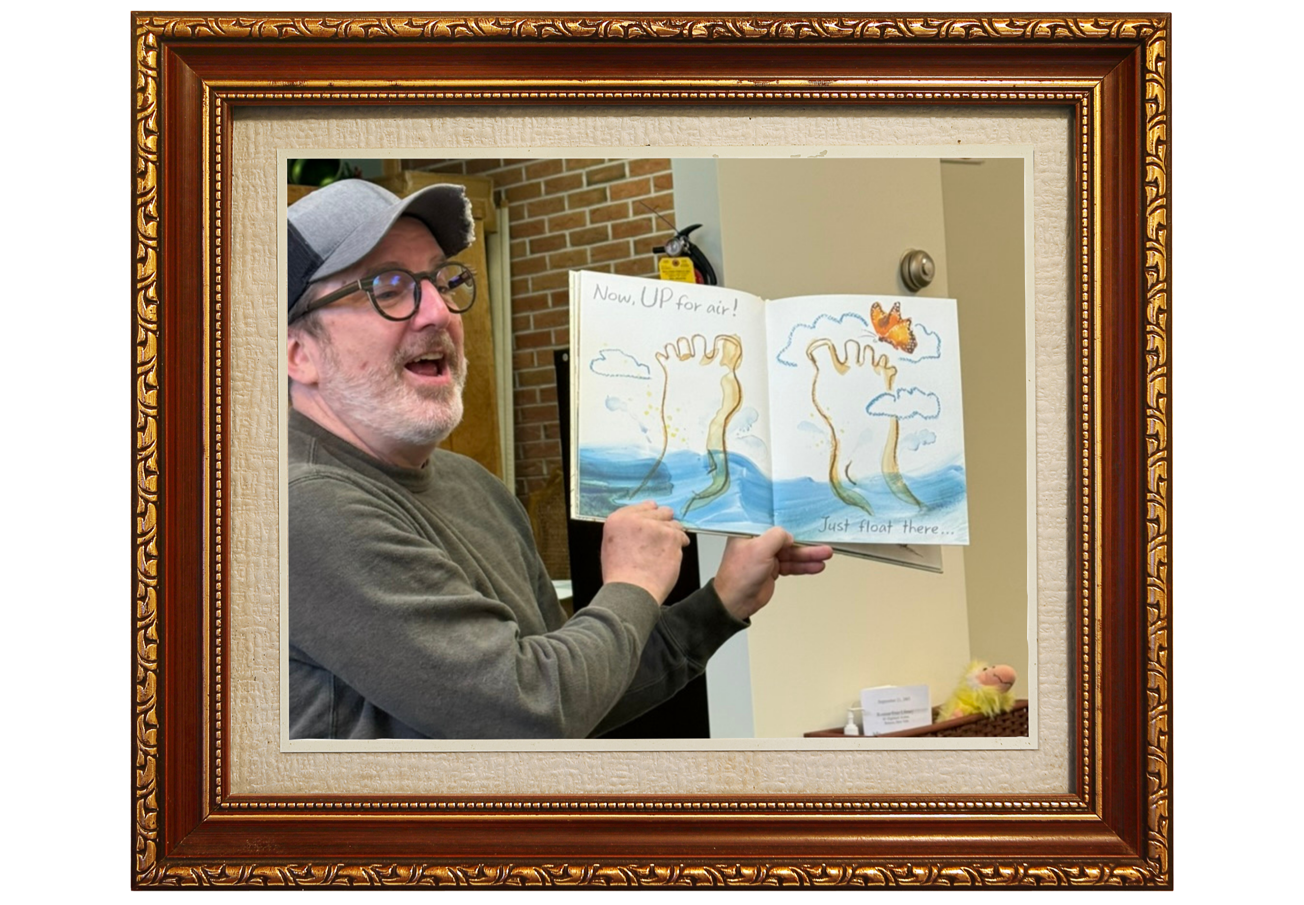 Man holding illustrated book in gold frame